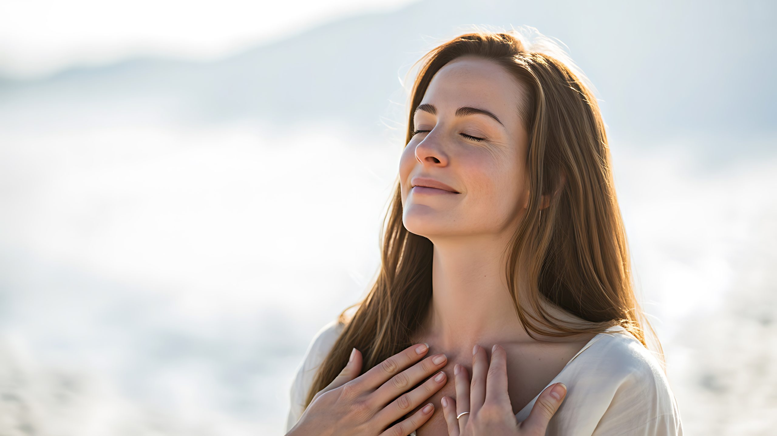 A mother with her eyes closed and her hands on her heart