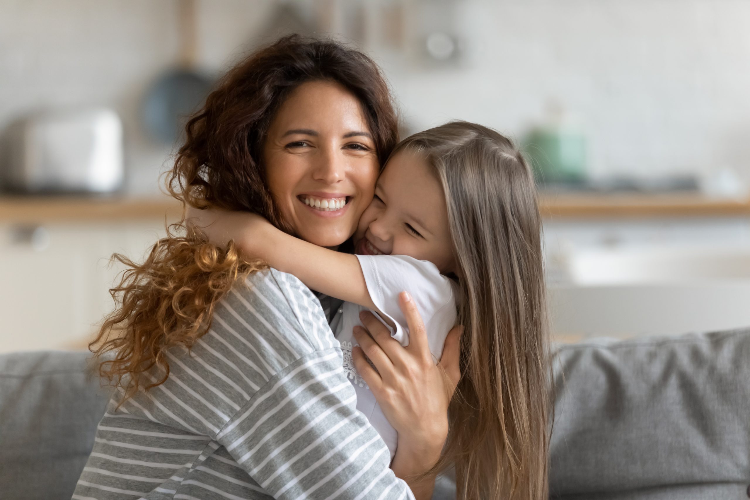 A mother hugging her daughter at home